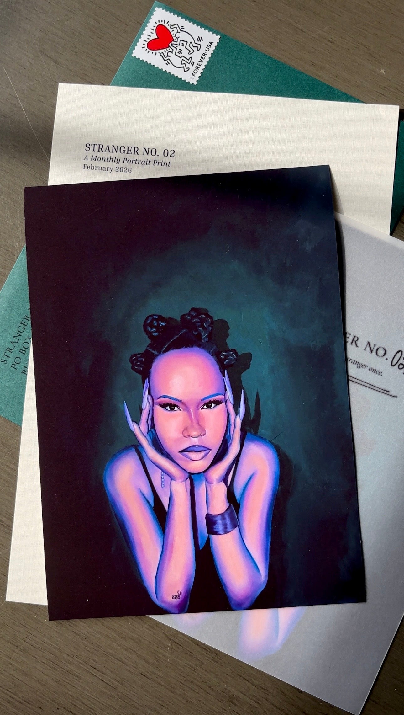 Artistic print of a person with hands on face on a dark background, placed on top of envelopes.
