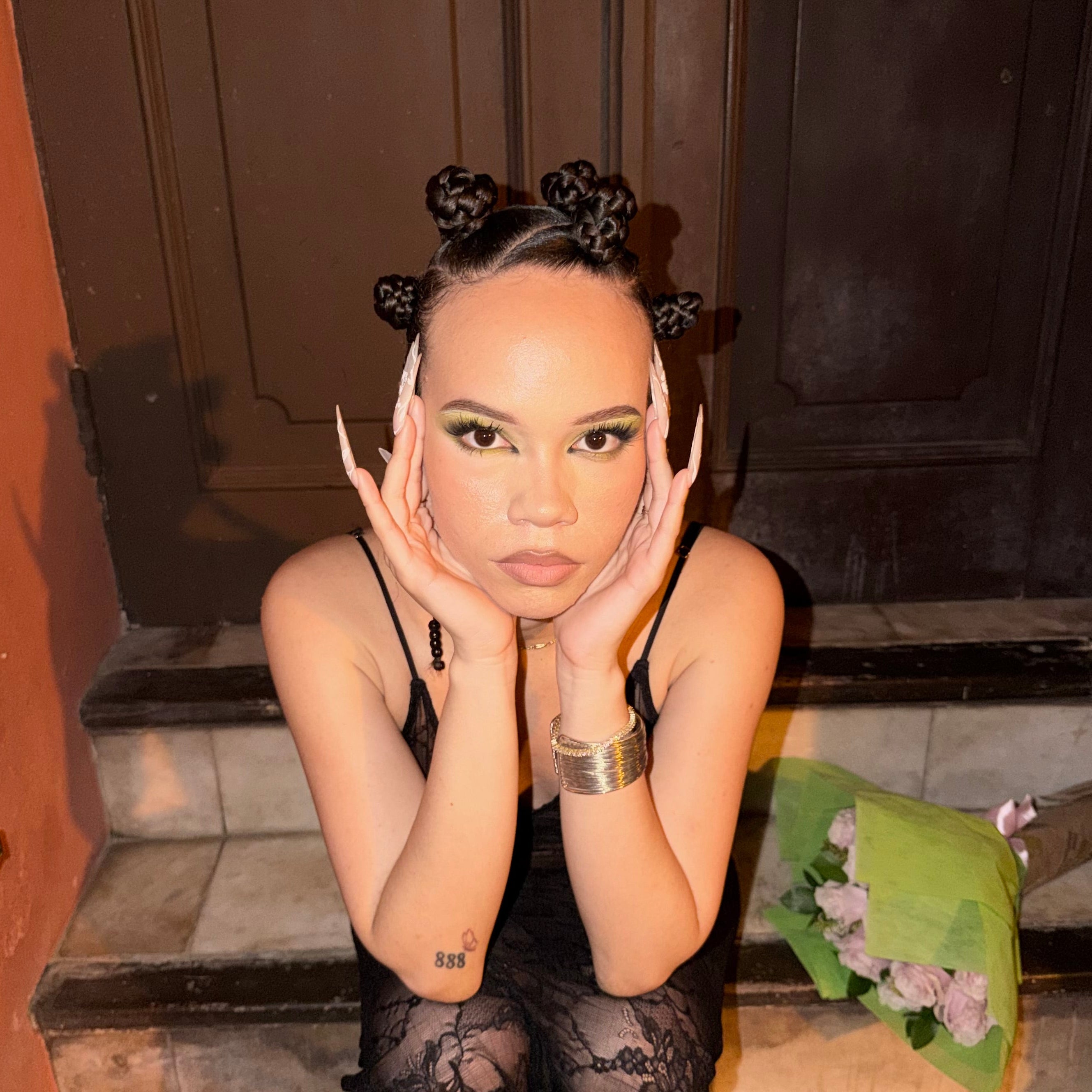 Person wearing a black lace dress sitting on steps.