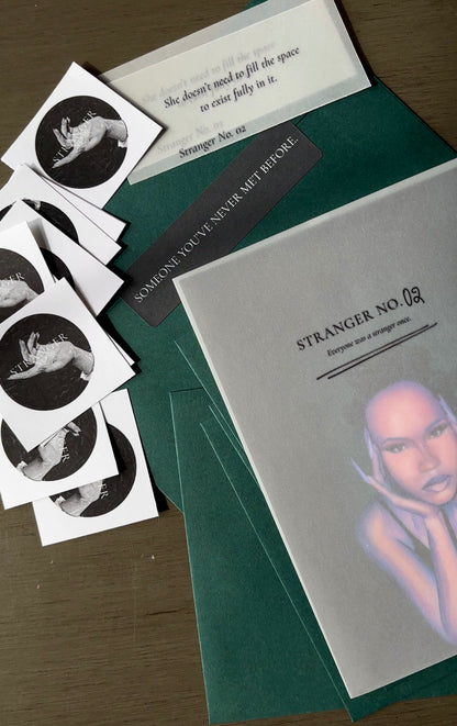 Collection of 'Stranger No. 02' cards and stickers on a wooden surface.