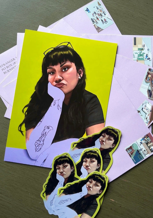 A set of custom printed stickers featuring a portrait of a woman with dark hair and glasses, displayed on a dark wooden table alongside light purple envelopes.